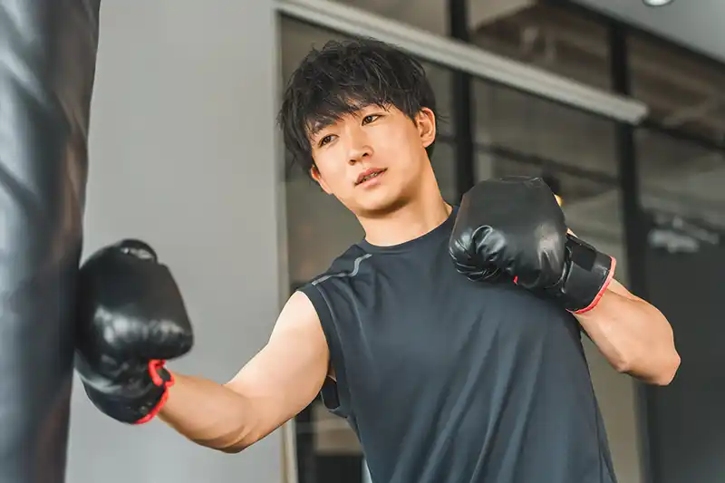 サンドバックを打つ男性